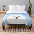 Samoyed puppy on a plush, white blanket