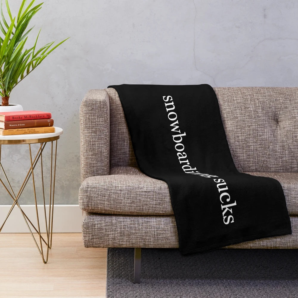 Plush black and white blanket with the text "snowboarding sucks" for winter sports enthusiasts
