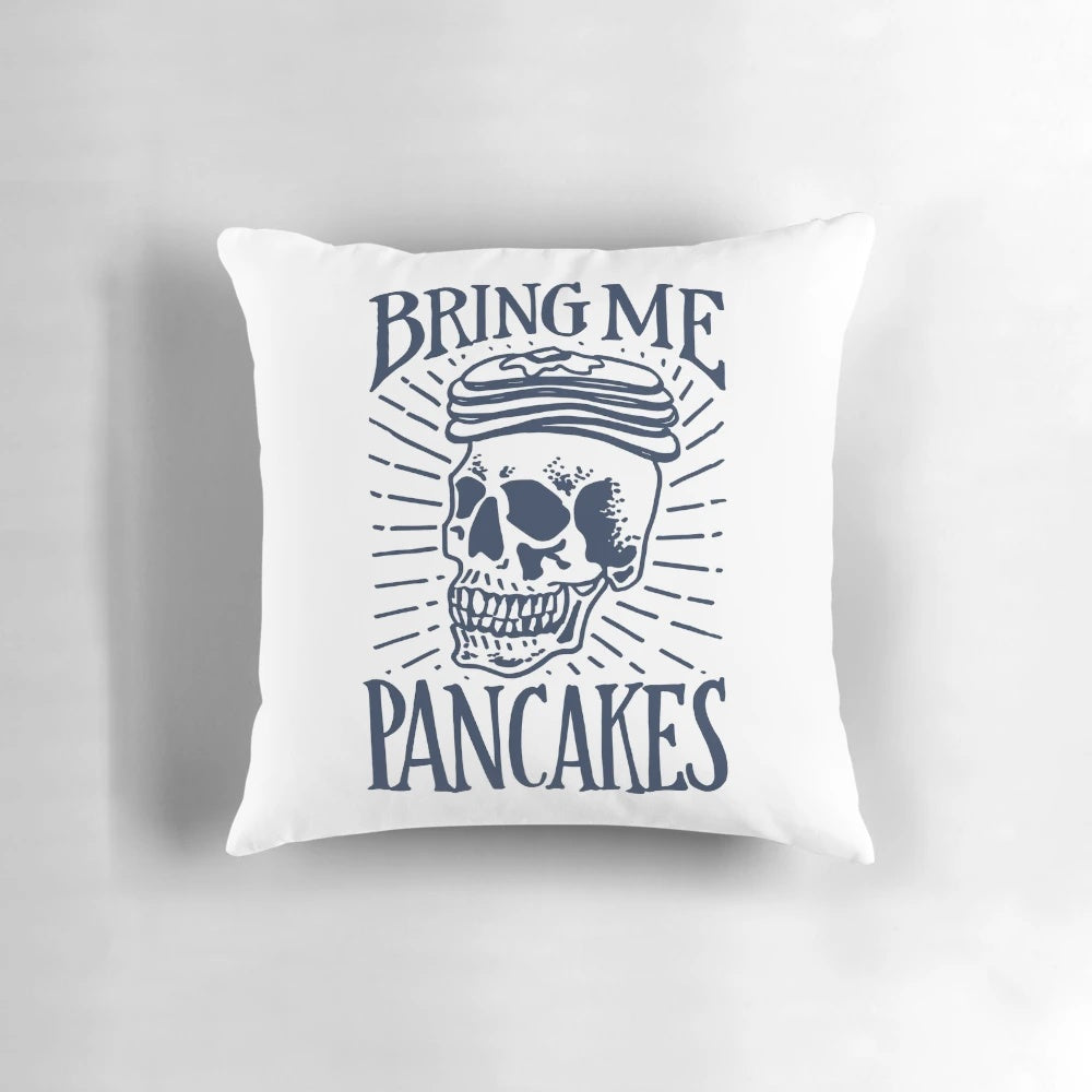A sassy hand-lettered throw pillow with a skull and the text "Bring Me Pancakes
