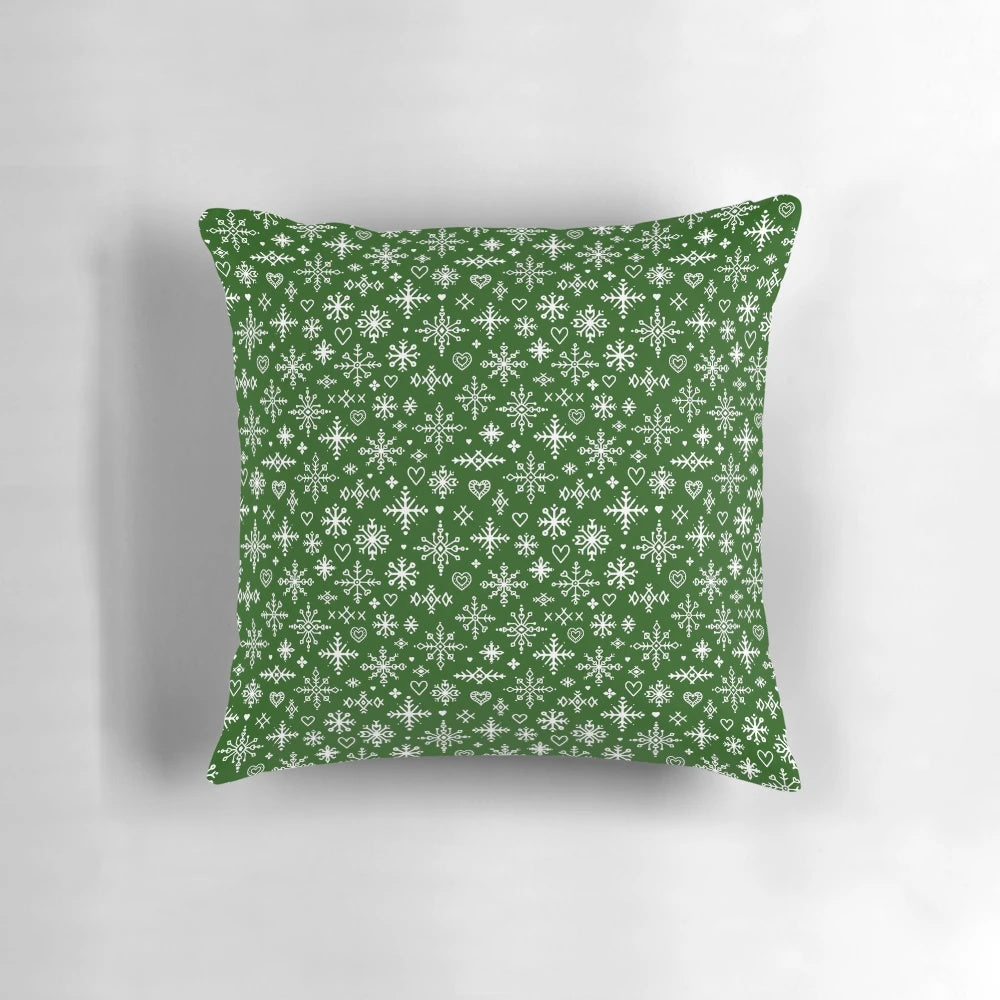 A white and green Scandinavian-style pillow with snowflake design, perfect for winter home decor.