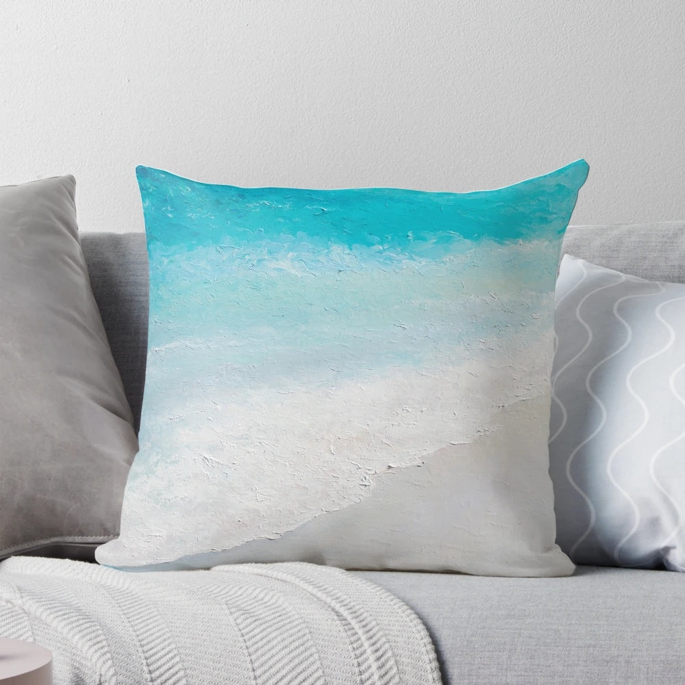 Decorative beach pillow featuring a vibrant seascape painting of crashing waves and a sandy shore.