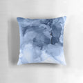 Stormy weather-inspired abstract blue and white pillow with fluid ink and textural elements