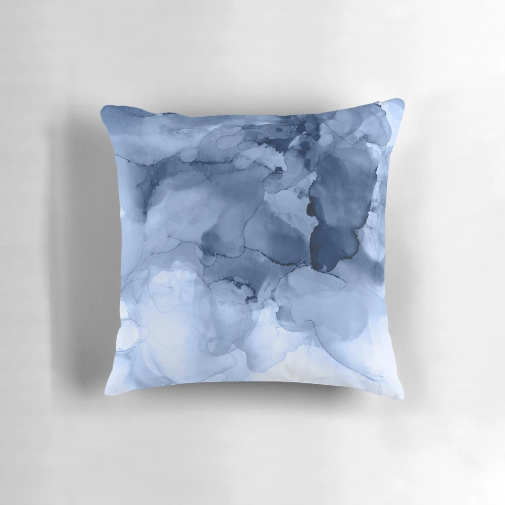 Stormy weather-inspired abstract blue and white pillow with fluid ink and textural elements