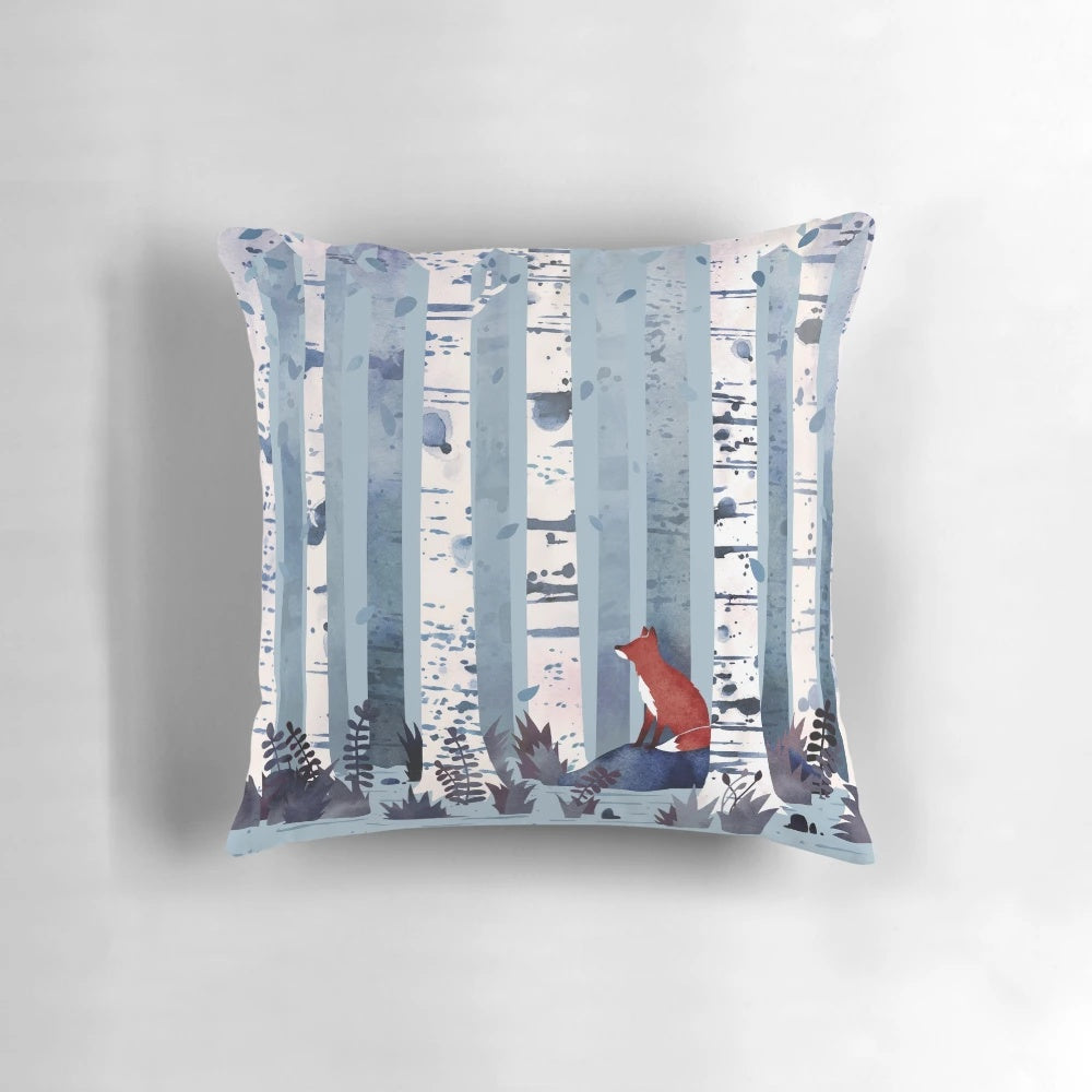 Blue and white watercolor painting of birch trees in a forest, featured on a decorative throw pillow.