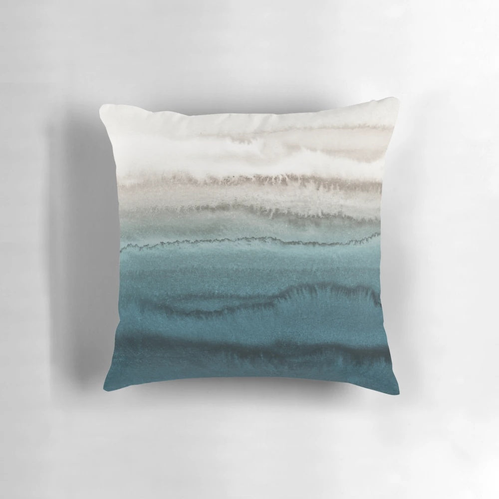 Decorative throw pillow featuring a watercolor abstract design of crashing ocean waves in shades of blue and green.