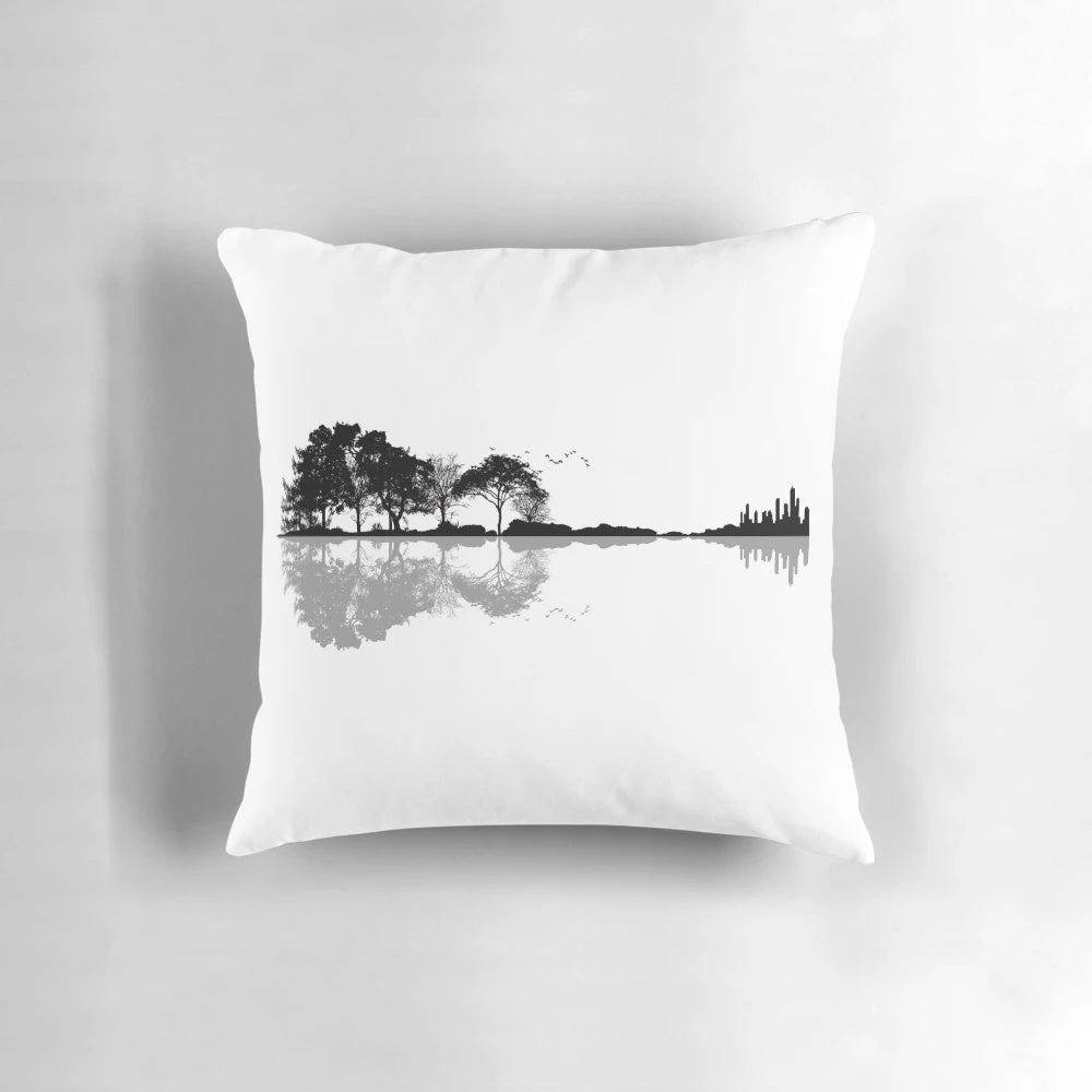 Artistic pillow design featuring a guitar silhouette against a nature landscape background