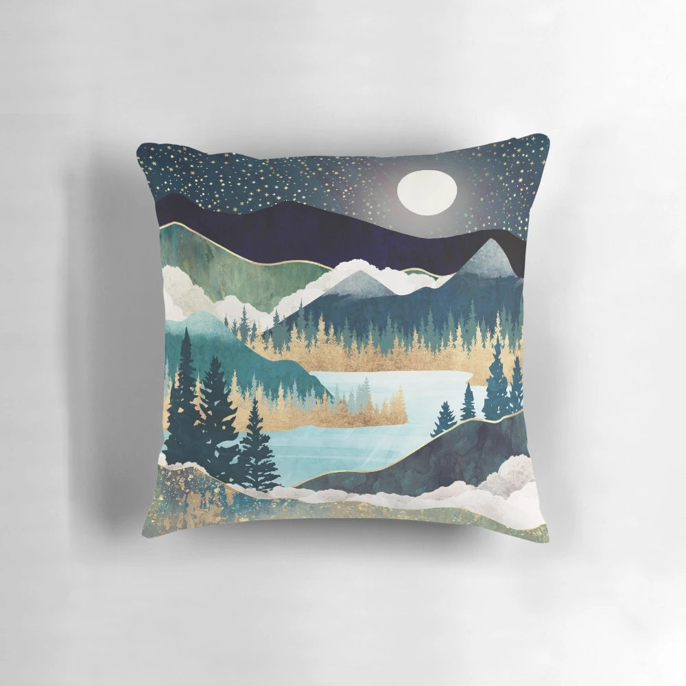 A tranquil pillow featuring a scenic landscape with a lake, mountains, and trees in shades of blue, teal, and green.