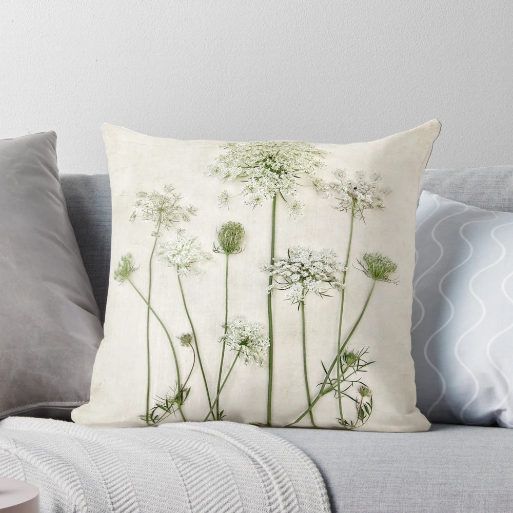 A beautiful Queen Anne's lace flower featured on a white and green minimalist pillow.