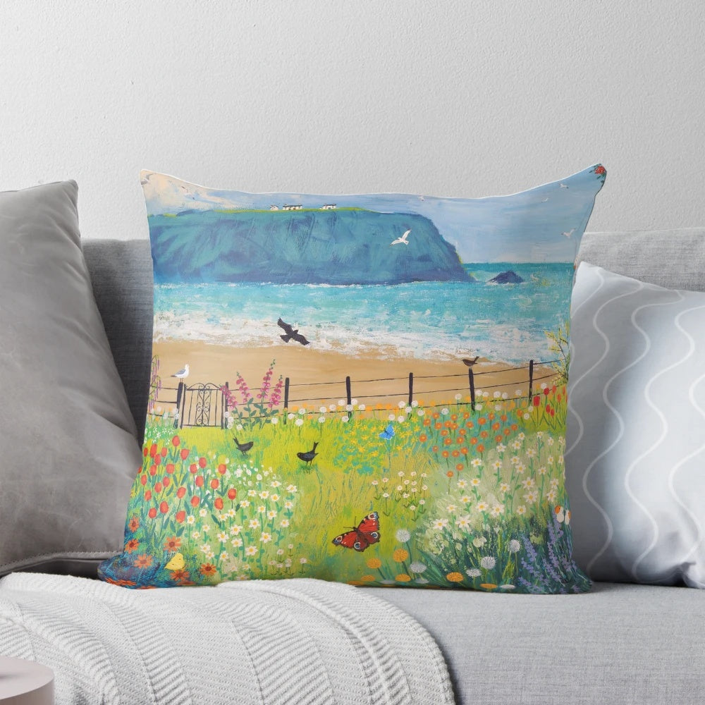 Decorative pillow featuring a painting of a garden by the sea with butterflies and birds