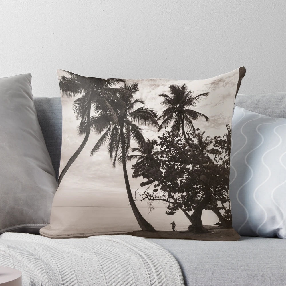 Sepia-toned image of palm trees leaning over a tranquil beach with the ocean in the background