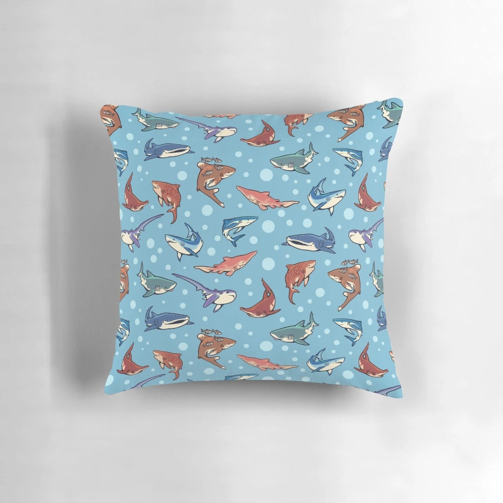 Decorative blue pillow featuring a vibrant pattern of various shark species swimming in the ocean.