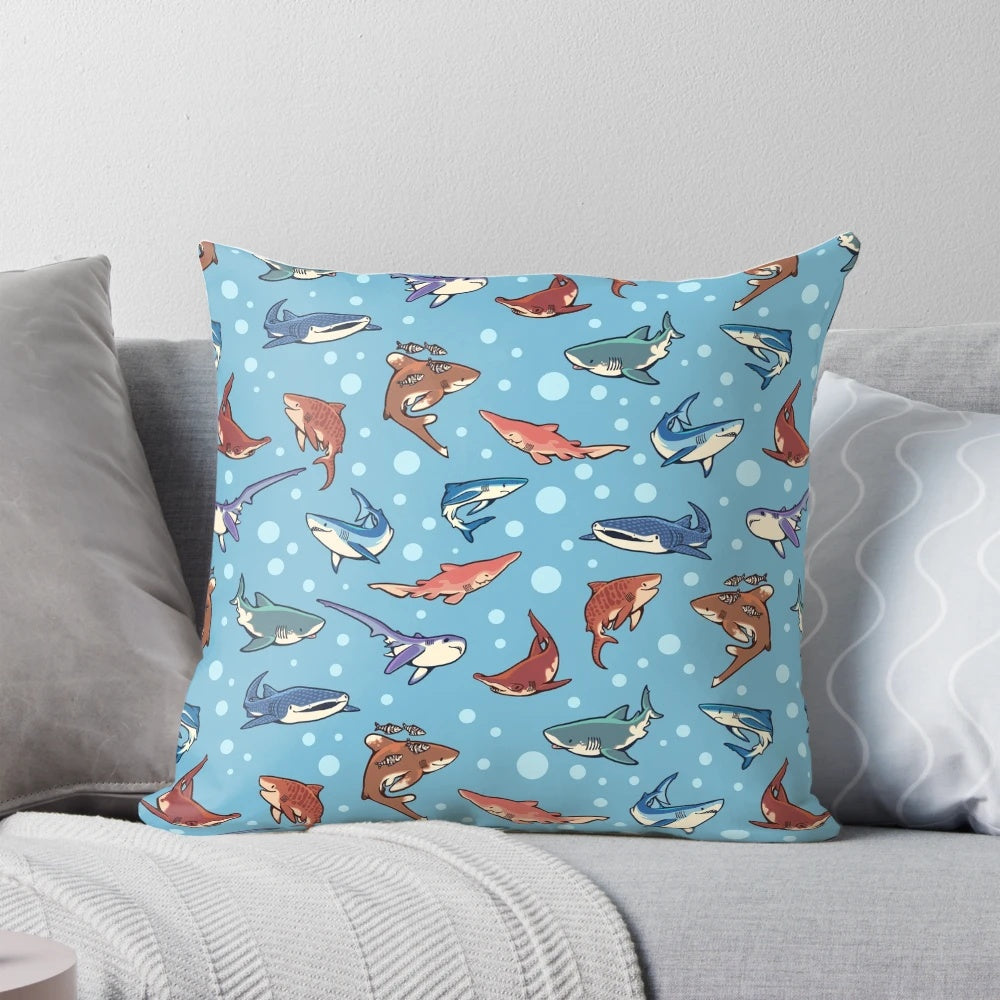 Decorative blue pillow featuring a vibrant pattern of various shark species swimming in the ocean.