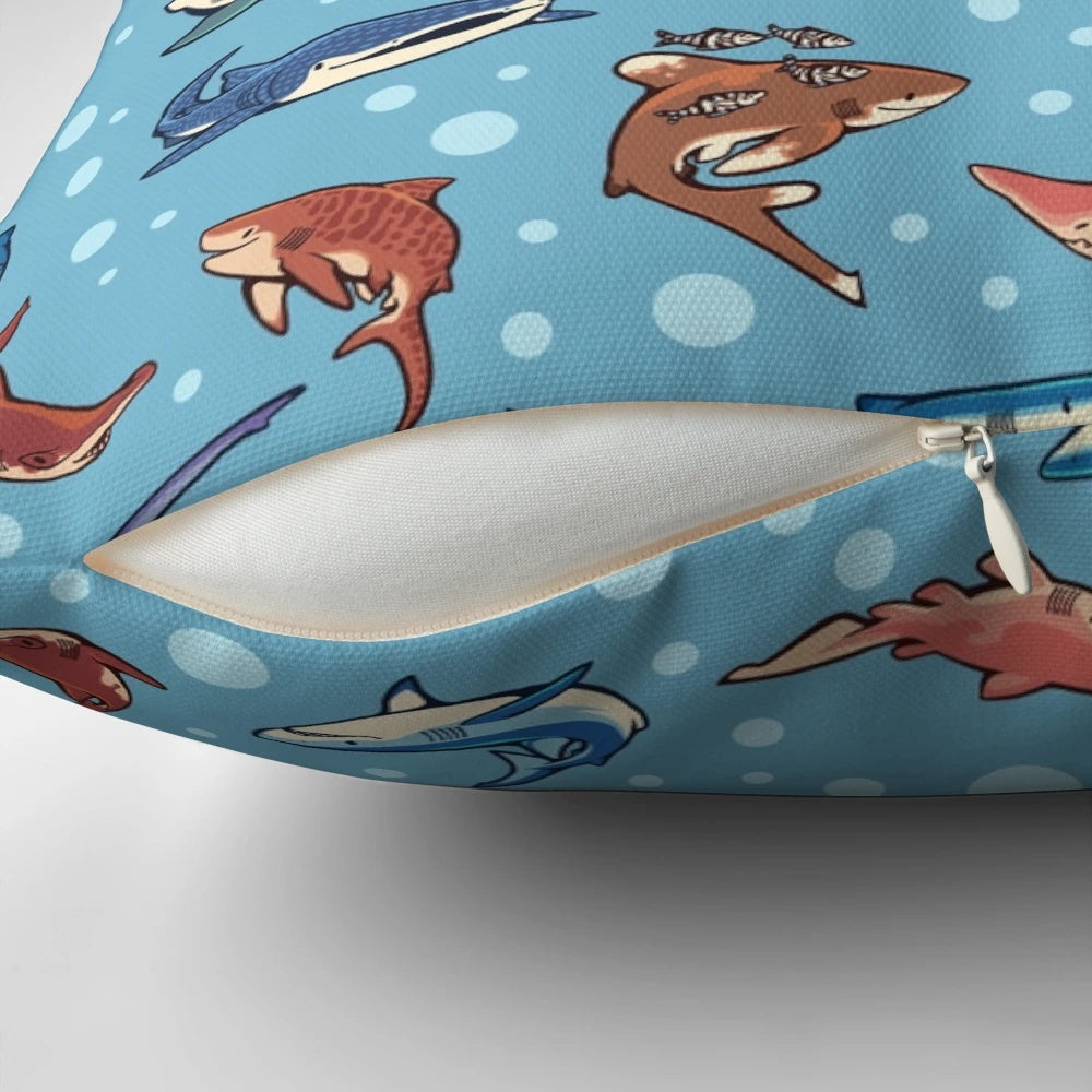 Decorative blue pillow featuring a vibrant pattern of various shark species swimming in the ocean.