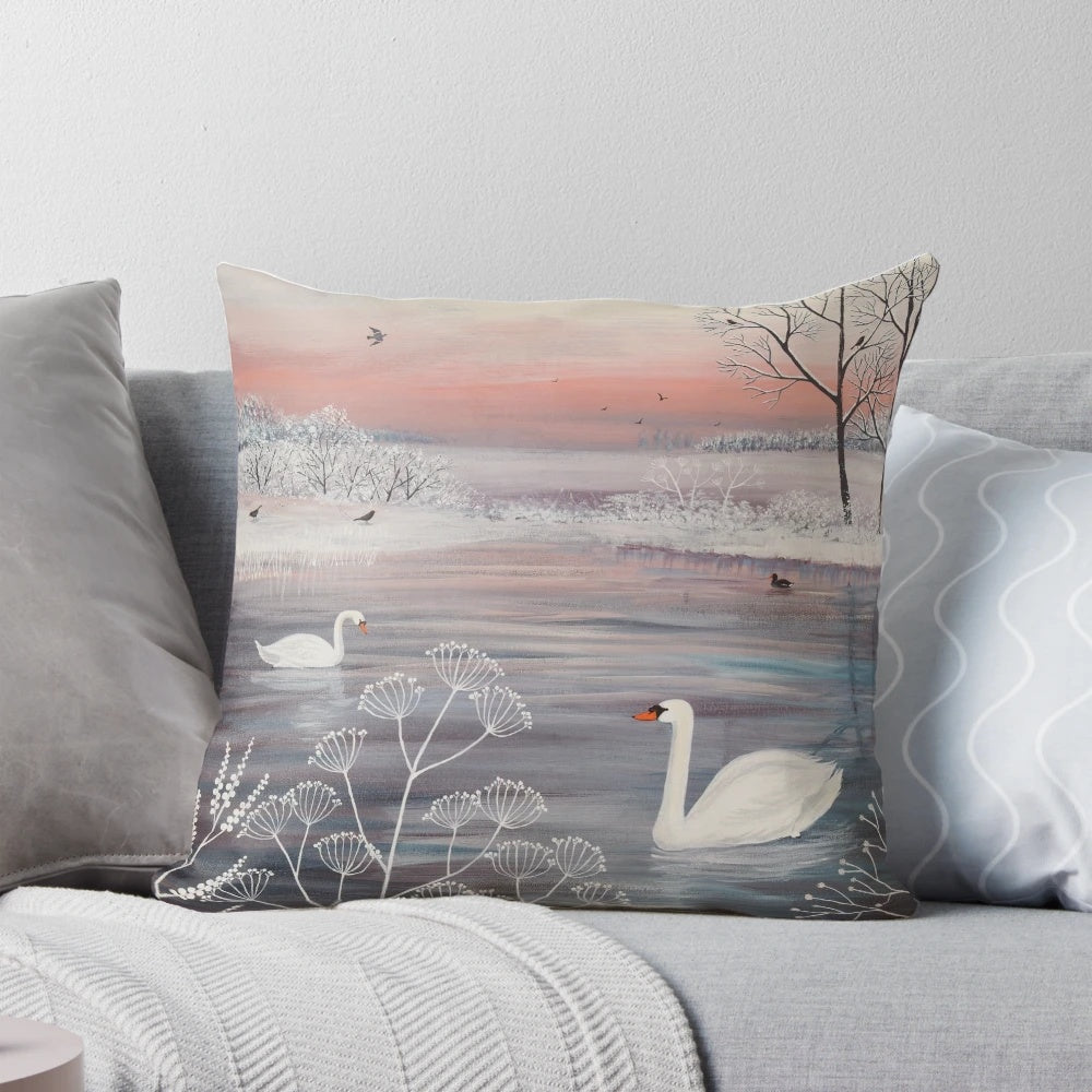A beautiful throw pillow featuring a serene winter landscape with snow-covered trees and a pair of graceful swans.