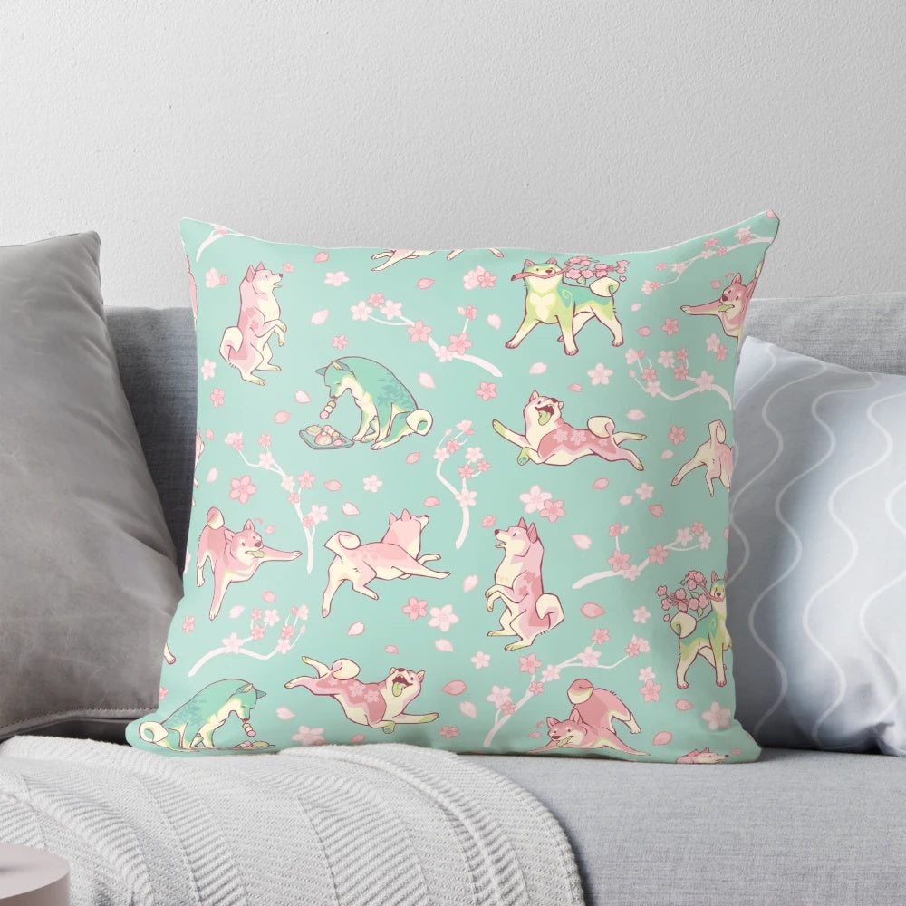 A beautiful mint green pillow featuring a design of a shiba inu dog surrounded by sakura blossoms and matcha leaves.