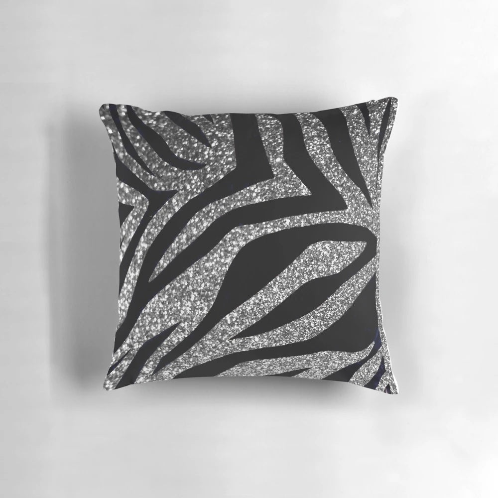 Photograph of a throw pillow with a silver glitter zebra print design.