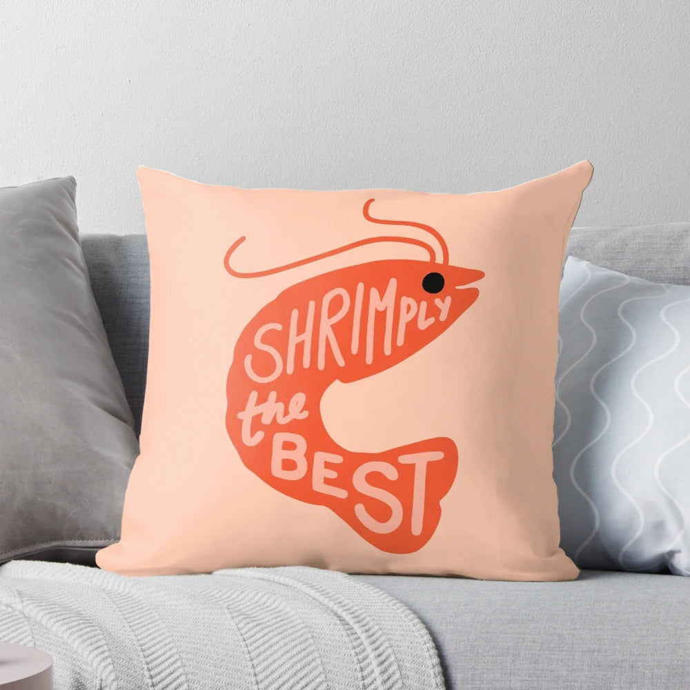 A red and pink cartoon shrimp pillow with the text "Shrimply the Best