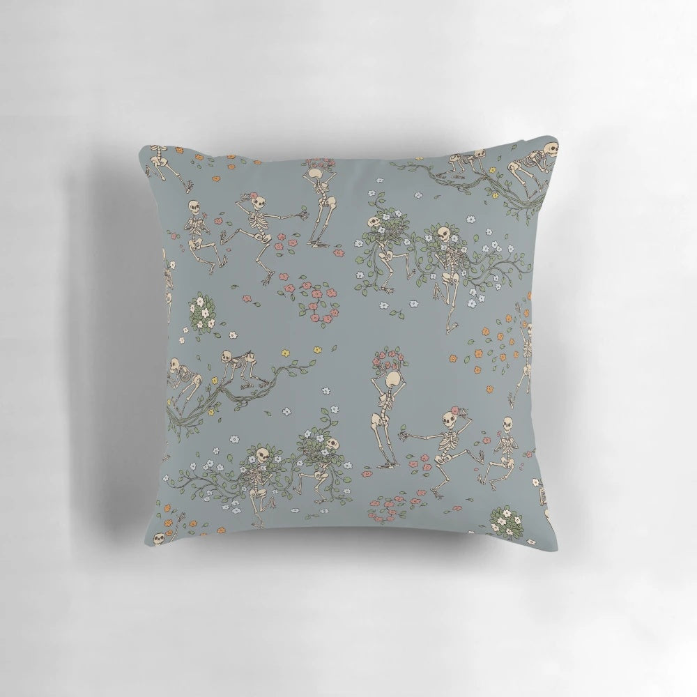 Decorative throw pillow featuring a skeleton design with floral garlands