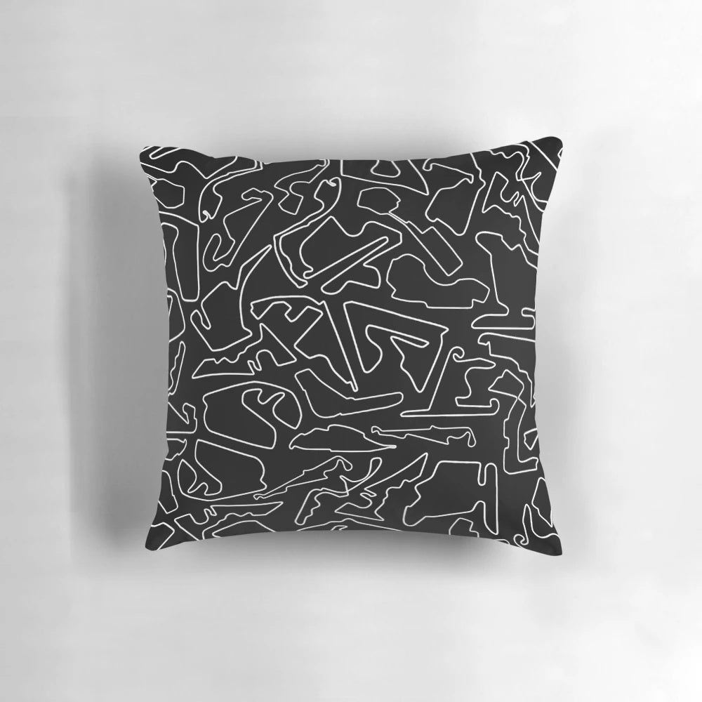 A decorative black and white pillow featuring a stylized race track design, perfect for motorsports enthusiasts.