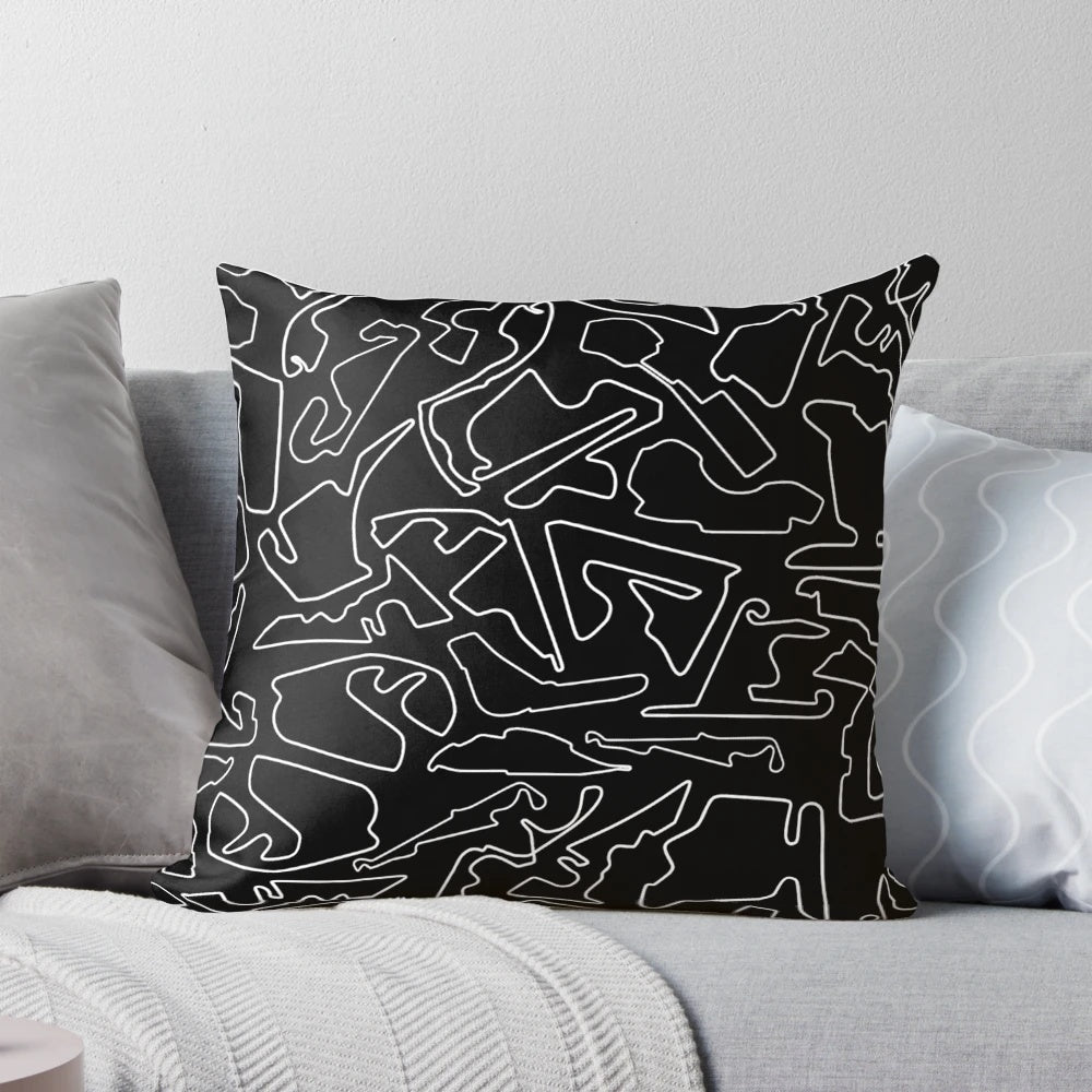 A decorative black and white pillow featuring a stylized race track design, perfect for motorsports enthusiasts.