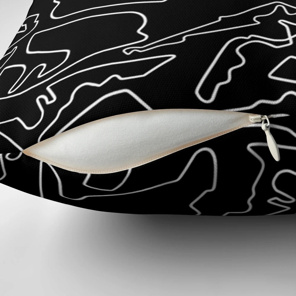 A decorative black and white pillow featuring a stylized race track design, perfect for motorsports enthusiasts.