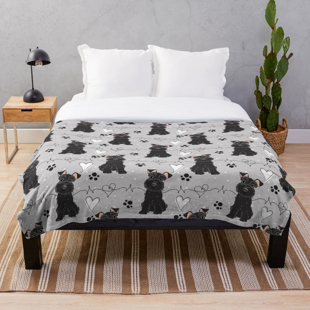 Black and white miniature schnauzer dog on a soft, plush blanket