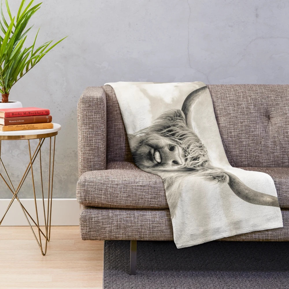A soft and cheeky highland cow plush blanket for cozy cuddling