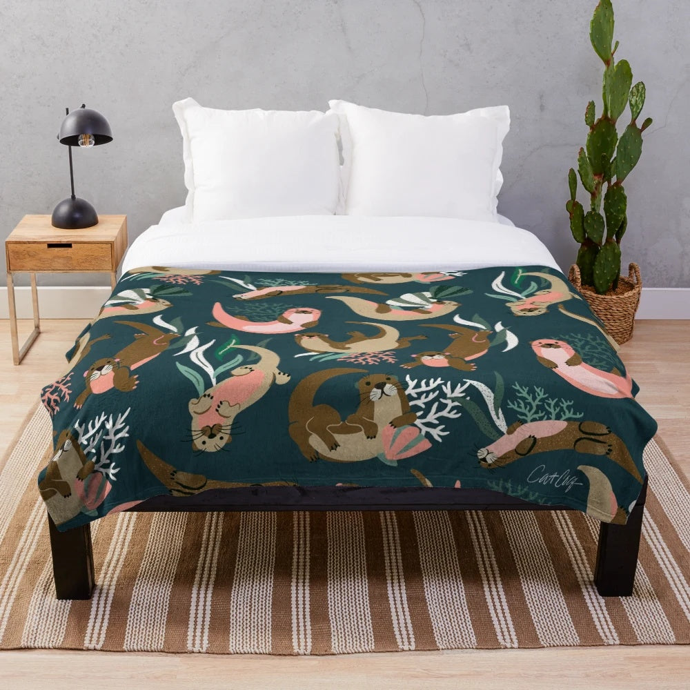 Otter-themed plush blanket in teal palette