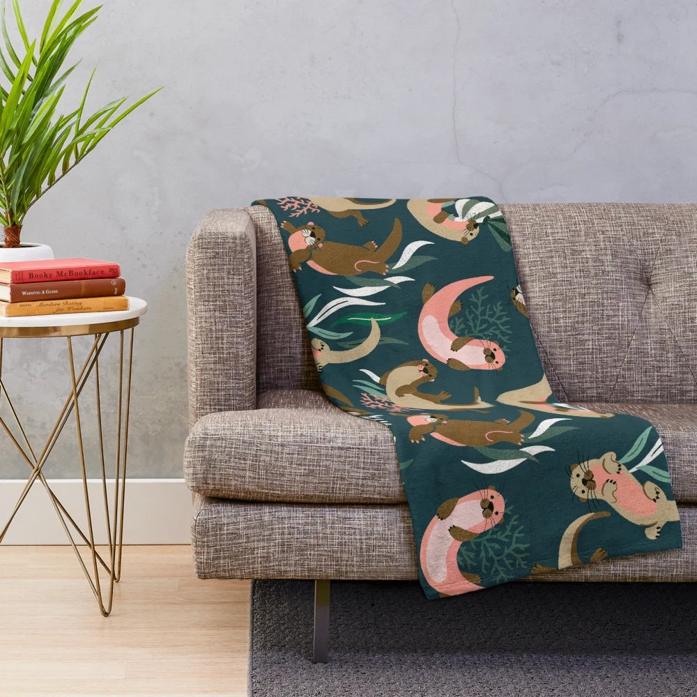 Otter-themed plush blanket in teal palette