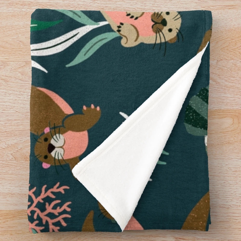 Otter-themed plush blanket in teal palette