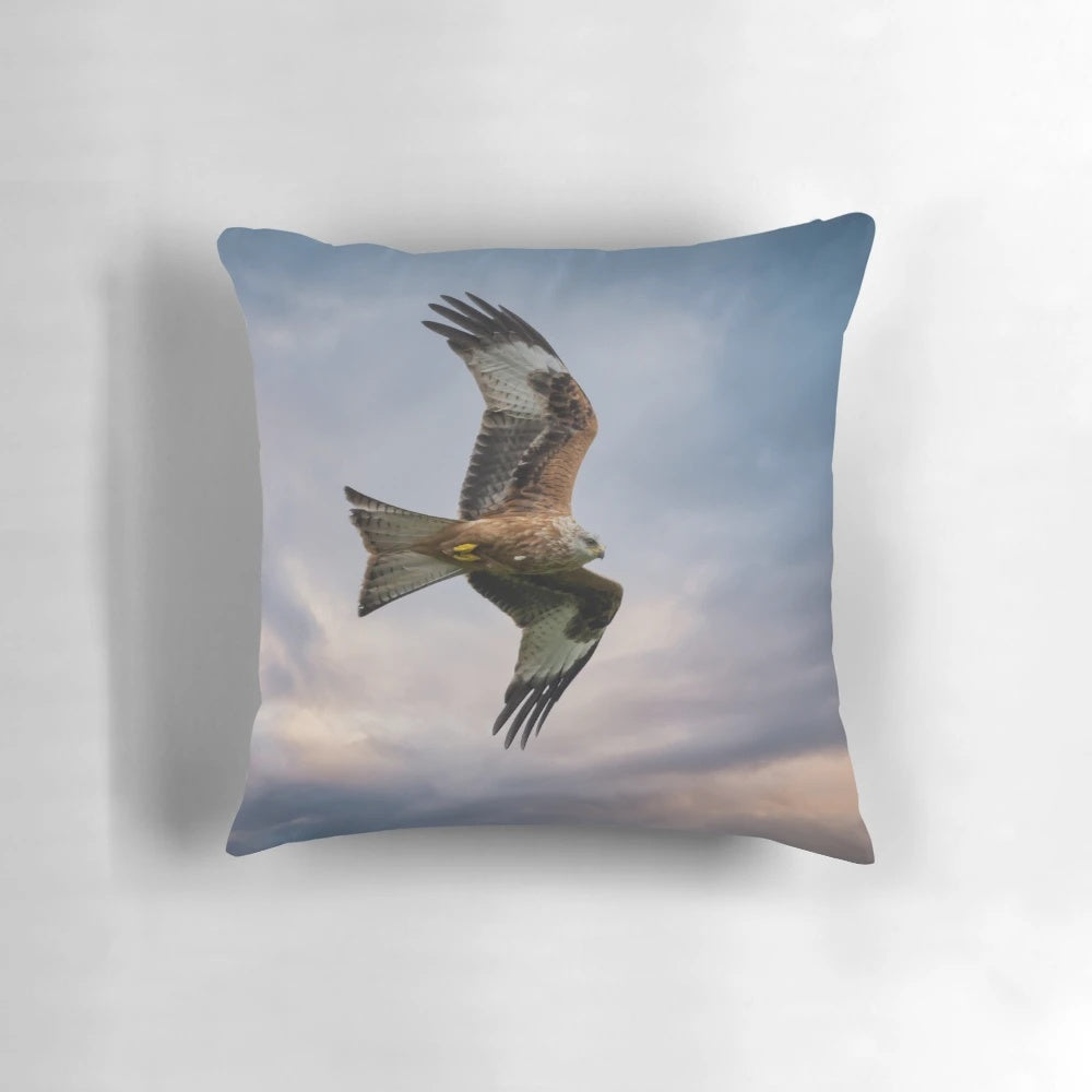 A vibrant red kite soaring through the sky on a decorative throw pillow