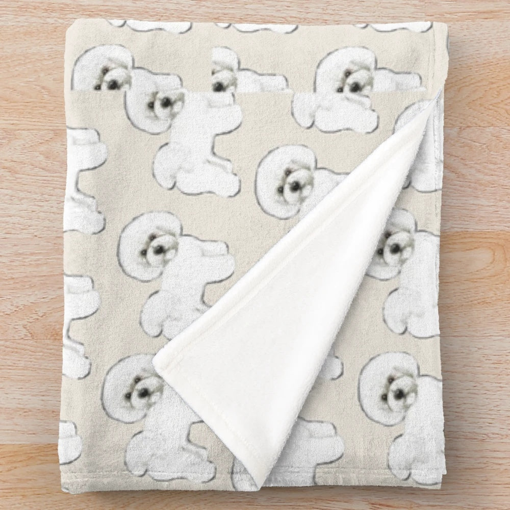 Bichon Frise dog on a creamy white plush blanket