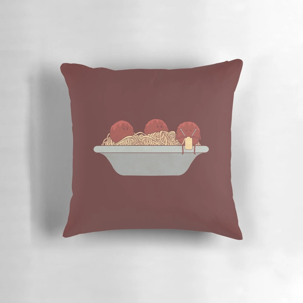 A soft and plush pillow featuring a knitting design and spaghetti and meatballs motif.