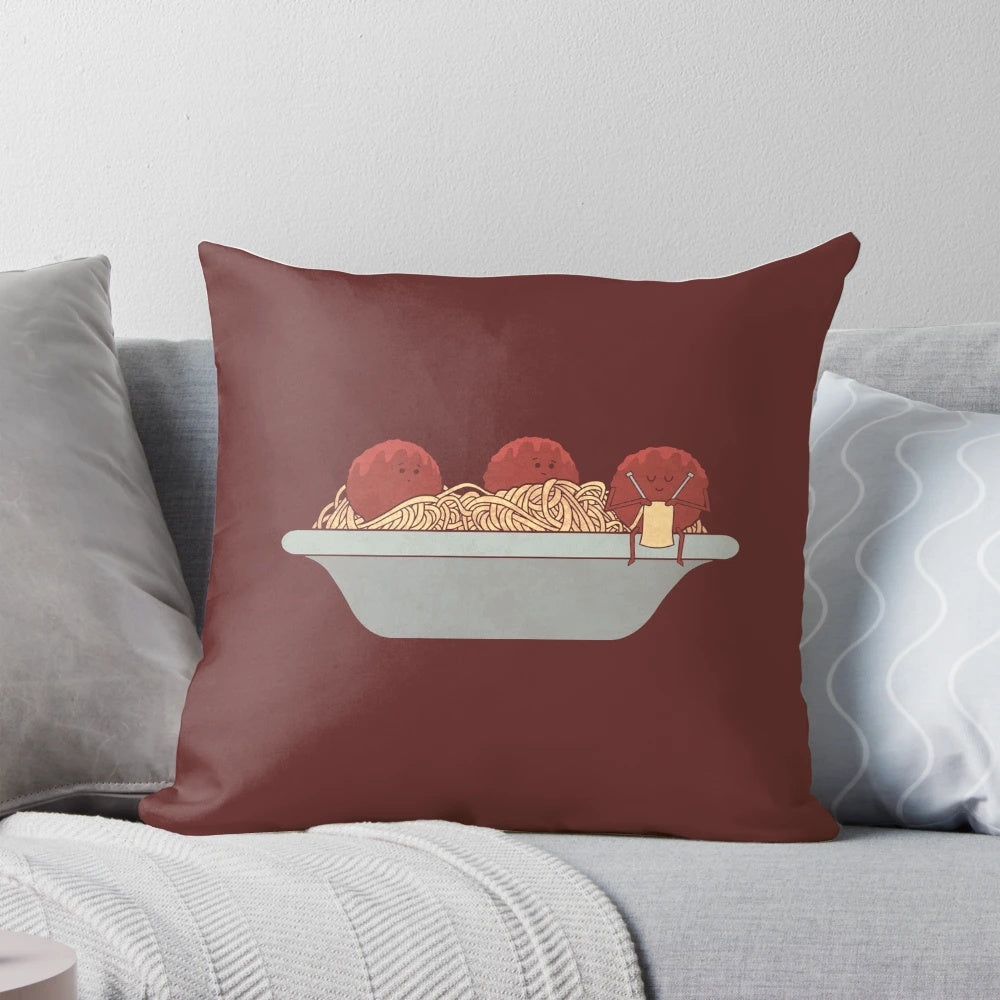 A soft and plush pillow featuring a knitting design and spaghetti and meatballs motif.