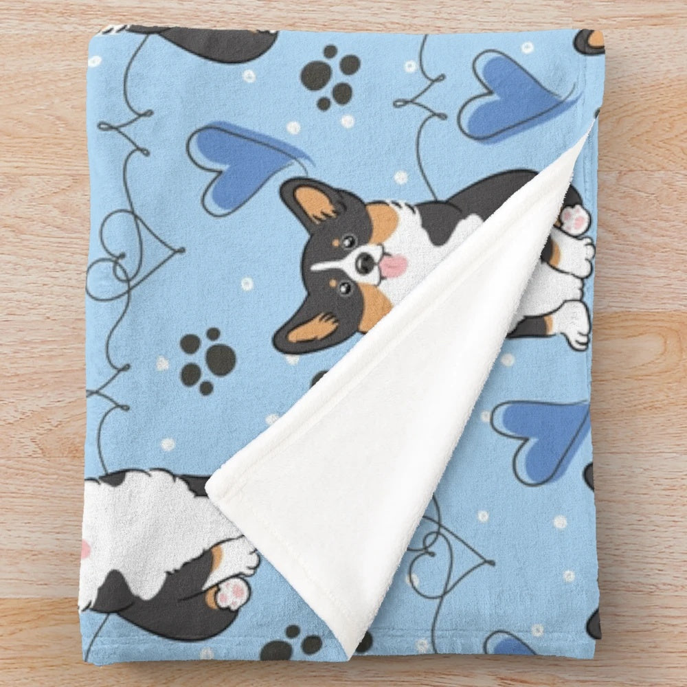 Black tri color corgi on a plush blanket