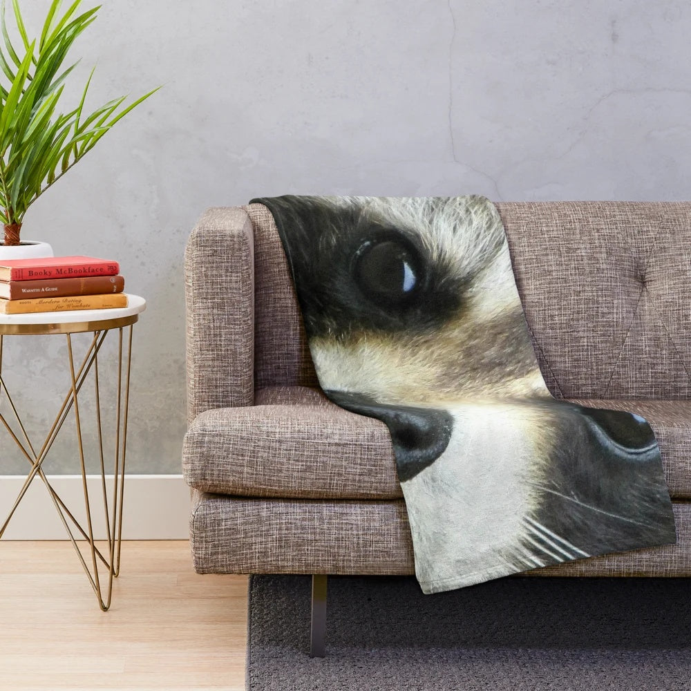 Soft and cozy plush blanket with a cute raccoon face design