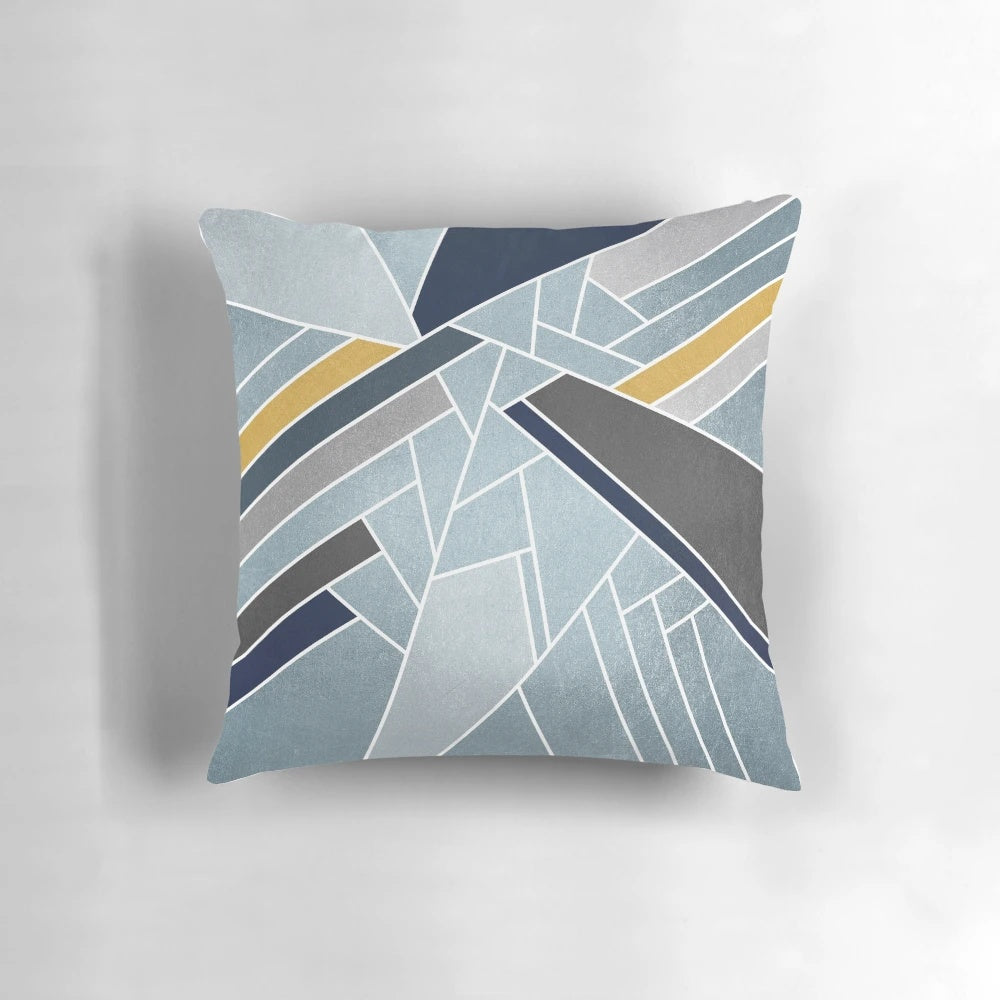 A soft, modern geometric mosaic pillow in navy, blue, and gold tones.
