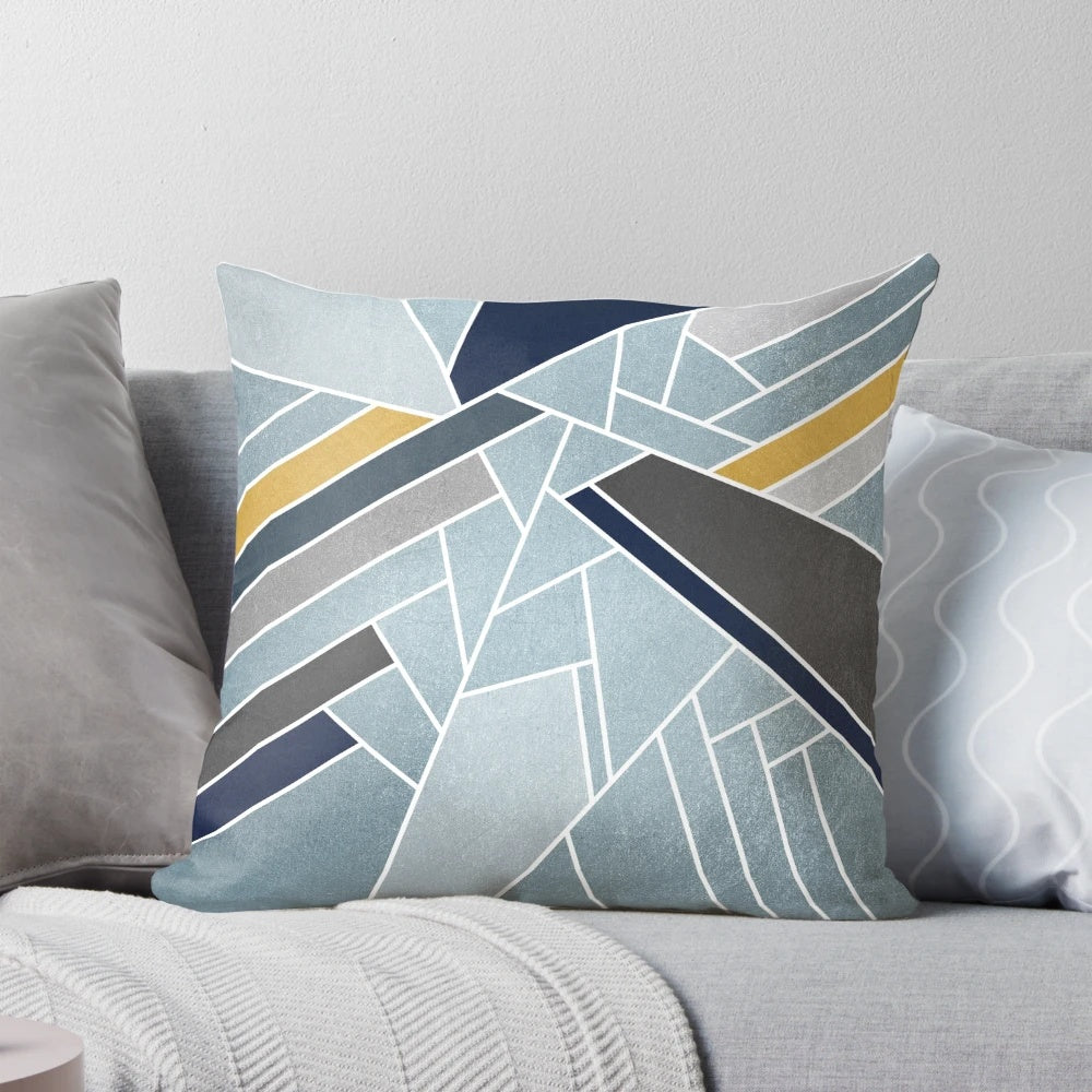 A soft, modern geometric mosaic pillow in navy, blue, and gold tones.