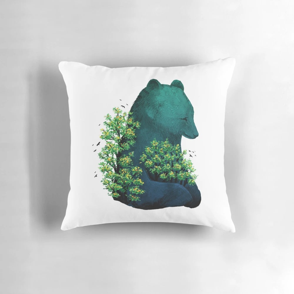 A soft, decorative pillow featuring a nature-inspired design with a bear hugging a tree surrounded by birds and a colorful landscape.