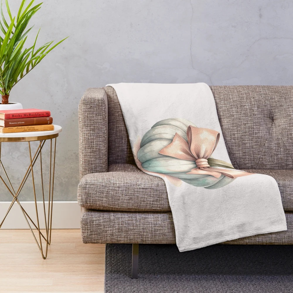 Soft pastel pumpkin plush blanket with a bow