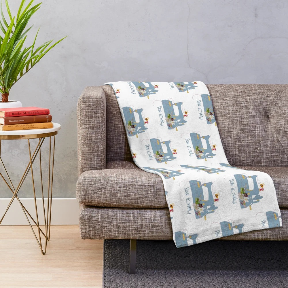 Cozy plush blanket featuring a sewing machine and floral embroidery pattern