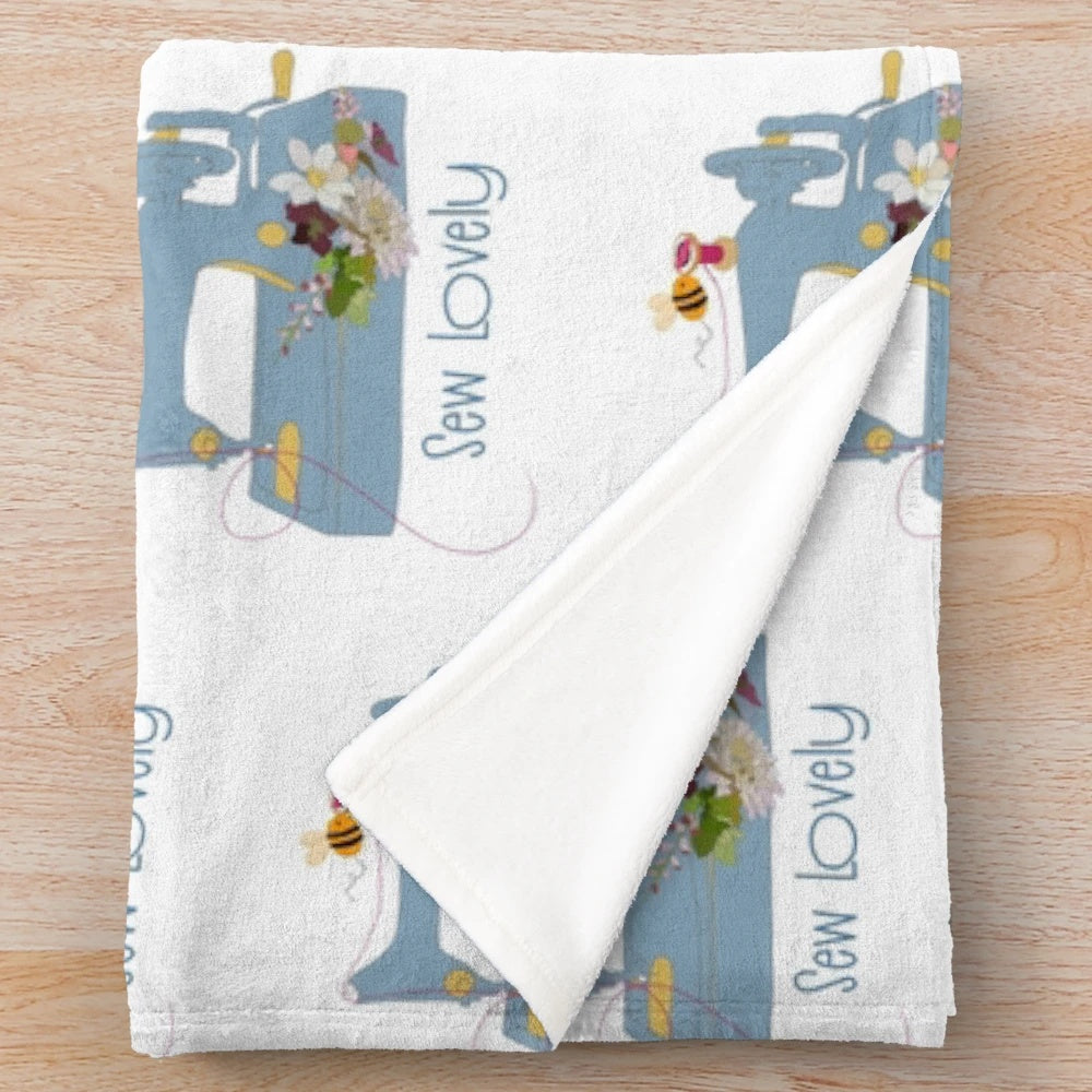 Cozy plush blanket featuring a sewing machine and floral embroidery pattern