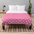 Soft and cozy plush blanket with a pink and white polka dots pattern
