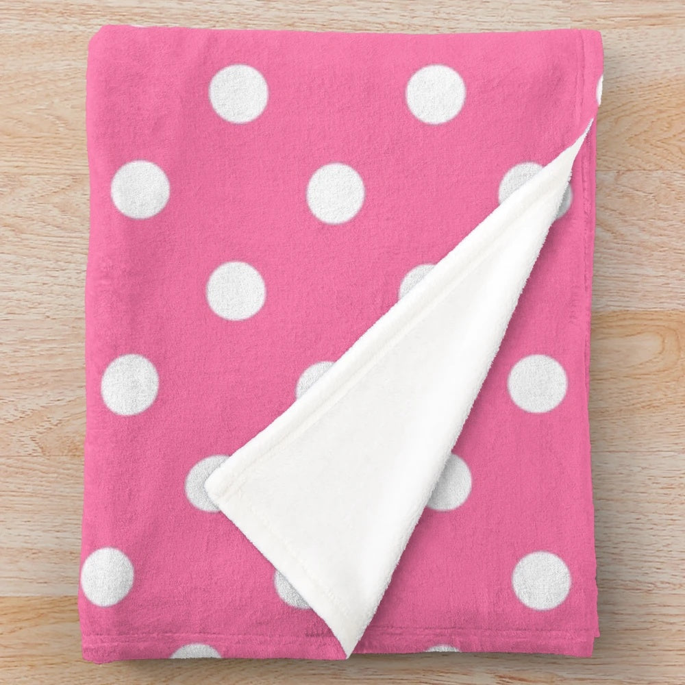 Soft and cozy plush blanket with a pink and white polka dots pattern