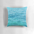 Vibrant turquoise ocean pillow with crashing waves, perfect for coastal-inspired home decor