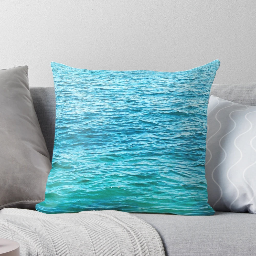 Vibrant turquoise ocean pillow with crashing waves, perfect for coastal-inspired home decor