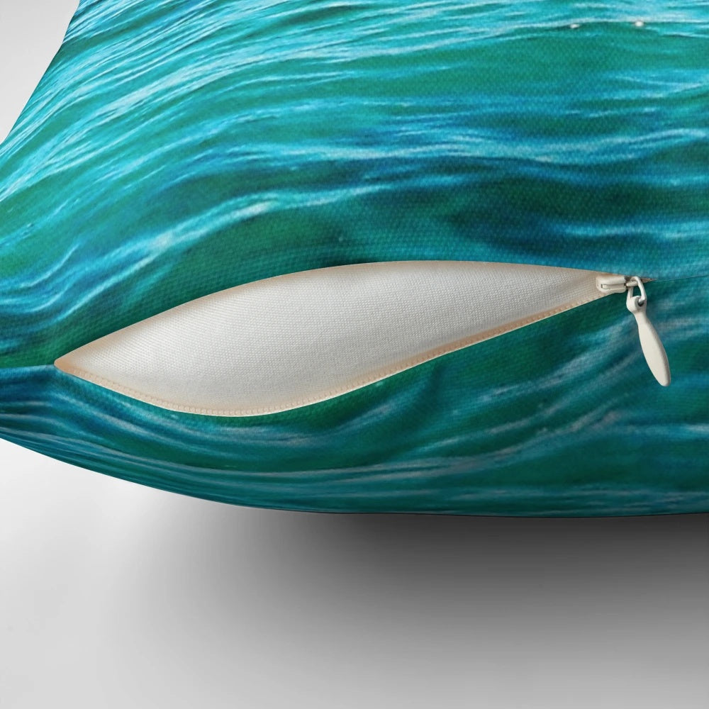 Vibrant turquoise ocean pillow with crashing waves, perfect for coastal-inspired home decor