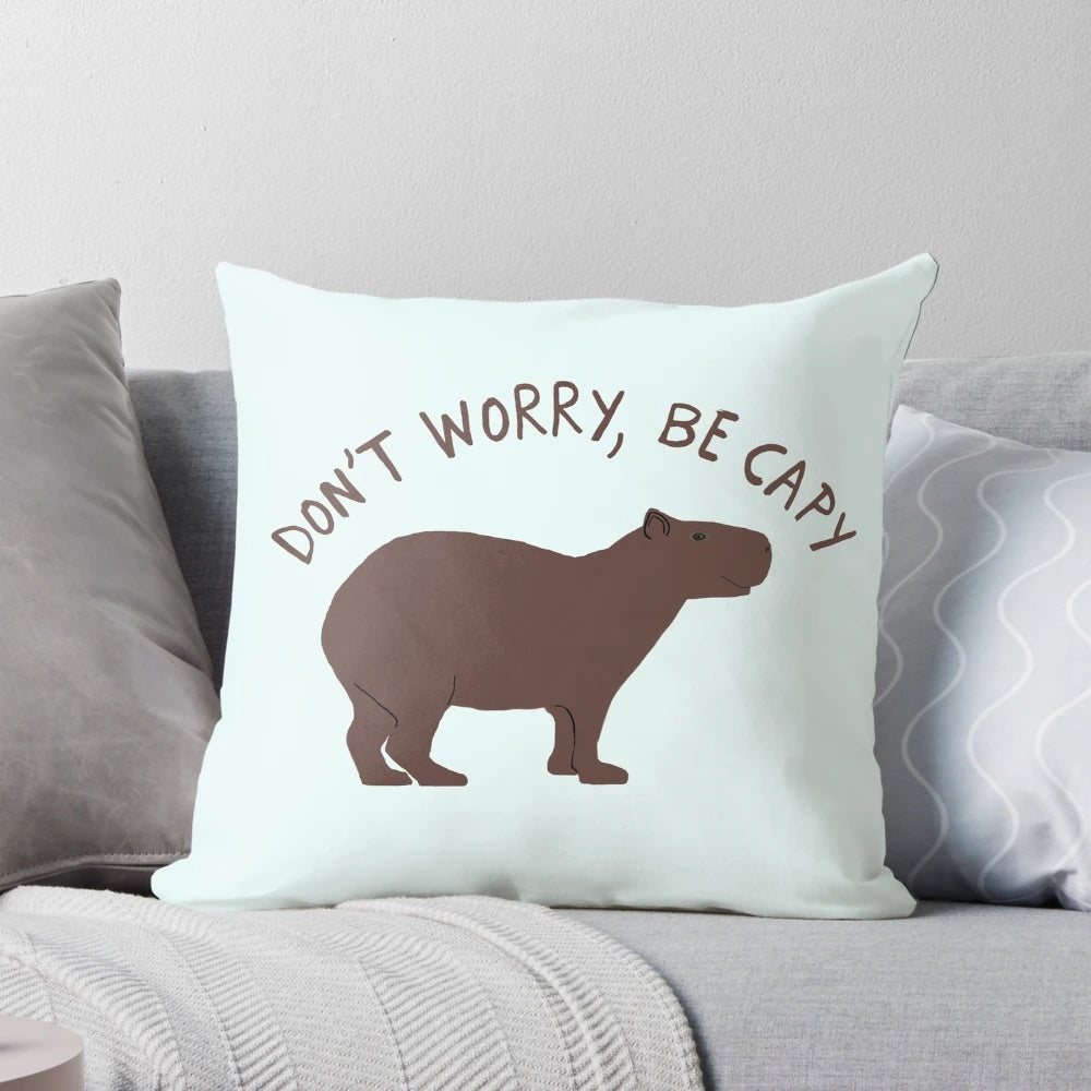 Capybara illustration on a soft, plush pillow with the text "Don't Worry, Be Capy