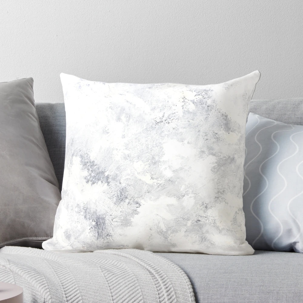 A serene white rabbit nestled in a captivating snowstorm, featured on a modern, minimalist pillow.
