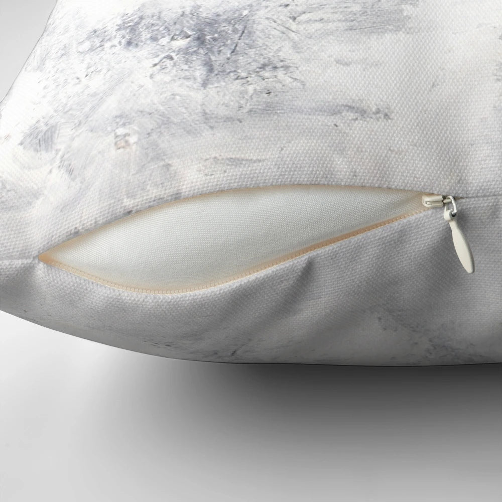 A serene white rabbit nestled in a captivating snowstorm, featured on a modern, minimalist pillow.